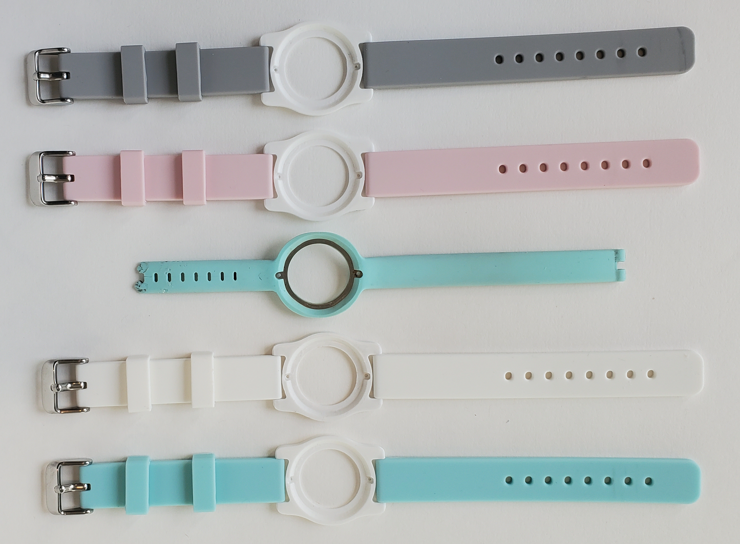 Comparison of teal, white, pink and gray color watch bands with original ripped Ava band.